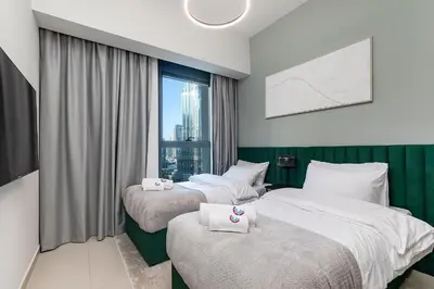 two beds in a hotel room with a window at Luxury Apartment with Burj Khalifa Views - 5-Min Walk to Dubai Mall - Newly Upgraded - 10 people - Near Dubai Opera in Dubai