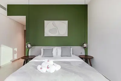 a bedroom with a bed with a green wall at Luxury Apartment with Burj Khalifa Views - 5-Min Walk to Dubai Mall - Newly Upgraded - 10 people - Near Dubai Opera in Dubai