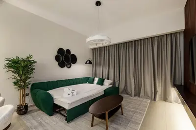 a living room with a green couch and a table at Luxury Apartment with Burj Khalifa Views - 5-Min Walk to Dubai Mall - Newly Upgraded - 10 people - Near Dubai Opera in Dubai