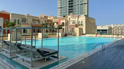 a large swimming pool in a city with buildings at TRPS - Binghatti Emerald, Jumeirah Village Circle - Luxury 1BR Haven in Dubai