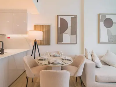 a living room with a table and chairs and a couch at TRPS - Binghatti Emerald, Jumeirah Village Circle - Luxury 1BR Haven in Dubai