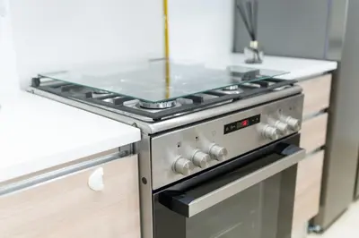 a kitchen with a stove with a counter top at Veluxa - Renovated 1BHK next to Golf in Dubai