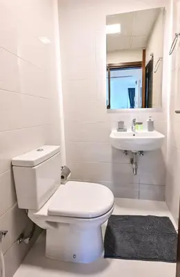 a white bathroom with a toilet and a sink at Stylish 1BR Apartment - Central Location in JVC - Balcony - Holiday Boulevard in Dubai