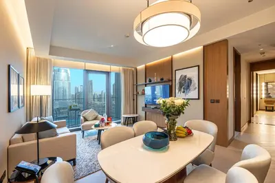 a living room with a table and chairs at Venetian - Stay at Address Opera with Burj & Fountain views in Dubai