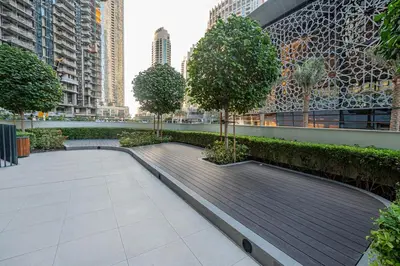 a boardwalk in a city with trees and buildings at Venetian - Refined 2BR at Grande Tower, Burj & Fountain views in Dubai