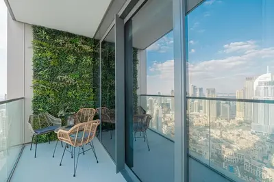 a balcony with chairs and a view of the city at Venetian - Refined 2BR at Grande Tower, Burj & Fountain views in Dubai
