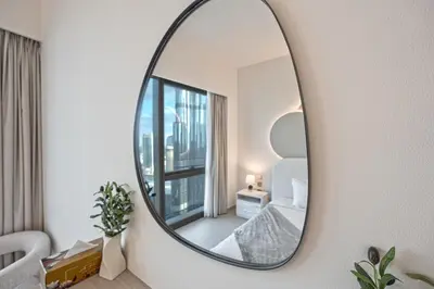 a mirror on a wall in a living room at Venetian - Refined 2BR at Grande Tower, Burj & Fountain views in Dubai