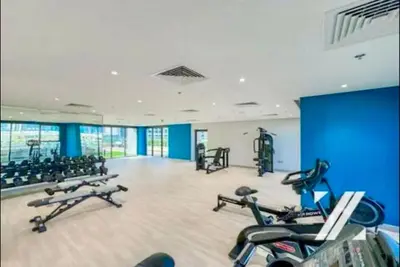 a gym with several treadmills and exercise bikes at Azizi Rivera 33 in Dubai