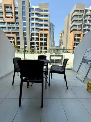 a patio with chairs and tables on a roof at Azizi Riviera 43 in Dubai