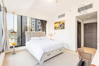 a bedroom with a white bed and a large window at Nomad Retreats- Silverene tower Marina view in Dubai