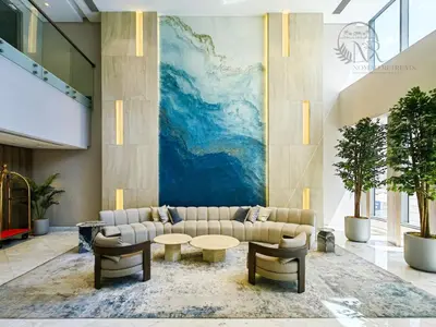 a lobby with a couch and tables and a mural at Nomad Retreats- Silverene tower Marina view in Dubai