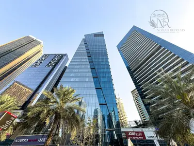 two tall buildings in a city with palm trees at Nomad Retreats- Silverene tower Marina view in Dubai