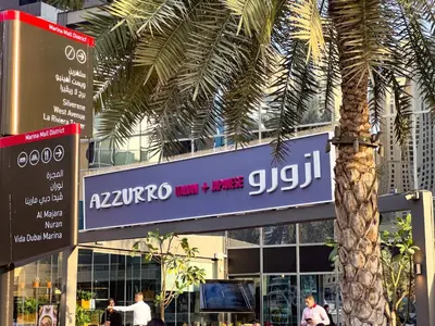 a sign in front of a building with a palm tree at Nomad Retreats- Silverene tower Marina view in Dubai