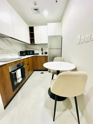 a kitchen with a table and two chairs and a refrigerator at Lake City Tower in Dubai