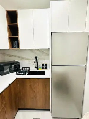 a stainless steel refrigerator in a kitchen with white cabinets at Lake City Tower in Dubai
