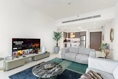 a living room with a couch and a tv at Fendi 1BR with Panoramic Sea View in Dubai