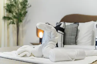 a pile of towels on a table with a bed at Fendi 1BR with Panoramic Sea View in Dubai