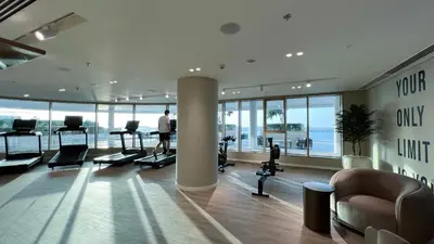a gym with a man exercising in a building at Fendi 1BR with Panoramic Sea View in Dubai