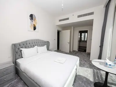 a bedroom with a large white bed and a table at Beachfront Family Entire Unit in Dubai Ras Al-Khor in Dubai