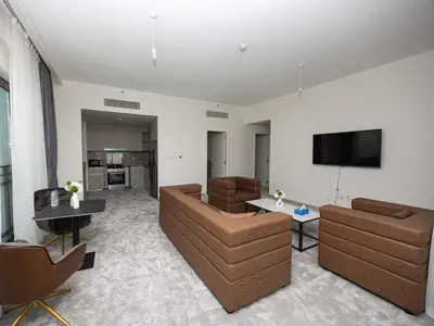 a living room with couches and a flat screen tv at Beachfront Family Entire Unit in Dubai Ras Al-Khor in Dubai