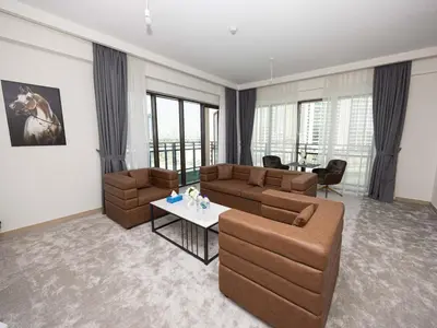 a living room with two couches and a table at Beachfront Family Entire Unit in Dubai Ras Al-Khor in Dubai