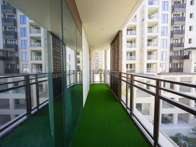 a balcony with green flooring in a building at Beachfront Family Entire Unit in Dubai Ras Al-Khor in Dubai