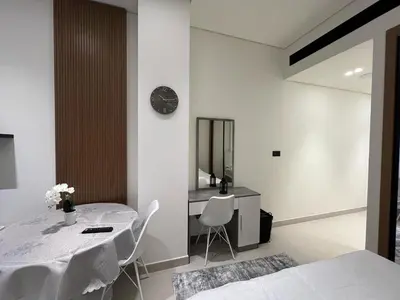 a dining room with a table and a clock on a wall at Luxury - Burj Khalifa View - Private Jacuzzi in Dubai