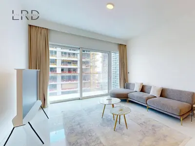 a living room with a couch and a tv at Waterfront 1 Bedroom Apartment - Private Beach - Emaar Beachfront in Dubai