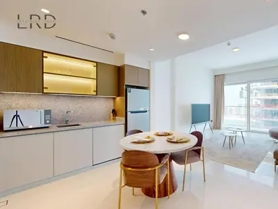 a kitchen and dining room with a table and chairs at Waterfront 1 Bedroom Apartment - Private Beach - Emaar Beachfront in Dubai
