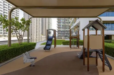 a playground with a slide and a swing at Waterfront 1 Bedroom Apartment - Private Beach - Emaar Beachfront in Dubai