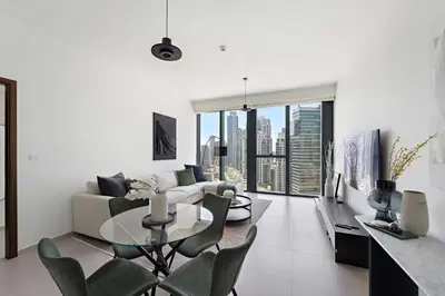 a living room with a couch and a table and chairs at Silkhaus Serene 1BR at Boulevard Heights in Downtown in Dubai