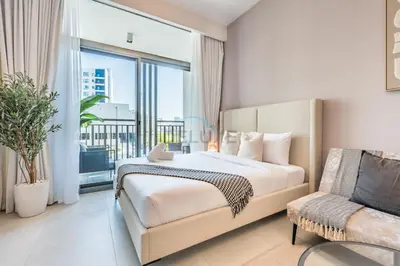 a bedroom with a bed and a couch and a window at Near Dubai Miracle Garden Studio with Community Views Balcony, Legacy by Sunrise, Arjan-Dubailand by Deluxe Holiday Homes in Dubai