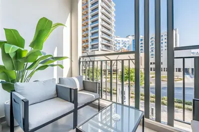 a living room with a couch and a glass table at Near Dubai Miracle Garden Studio with Community Views Balcony, Legacy by Sunrise, Arjan-Dubailand by Deluxe Holiday Homes in Dubai