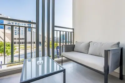 a living room with a couch and a glass table at Near Dubai Miracle Garden Studio with Community Views Balcony, Legacy by Sunrise, Arjan-Dubailand by Deluxe Holiday Homes in Dubai