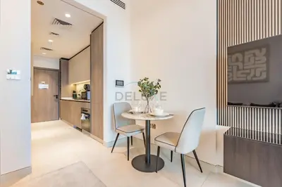 a dining room with a table and two chairs at Near Dubai Miracle Garden Studio with Community Views Balcony, Legacy by Sunrise, Arjan-Dubailand by Deluxe Holiday Homes in Dubai