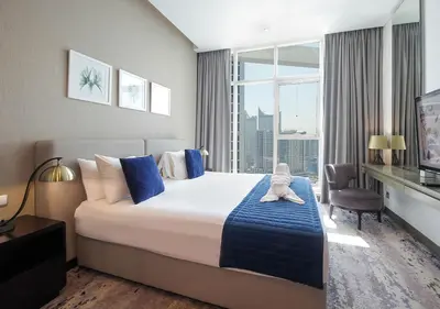 a hotel room with a large bed and a window at Stylish Studio Apartment in Dubai with Pool & Gym in Dubai