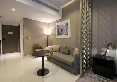 a living room with a couch and a table at Stylish Studio Apartment in Dubai with Pool & Gym in Dubai