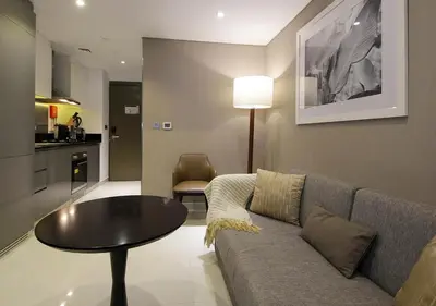 a living room with a couch and a table at Stylish Studio Apartment in Dubai with Pool & Gym in Dubai