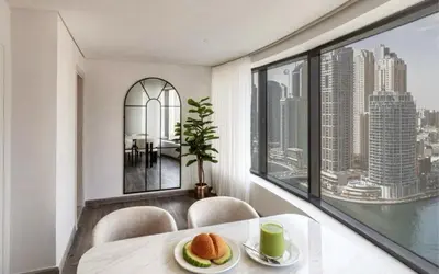 a dining room with a table and chairs and a window at Beautiful 3 bed In Dubai Marina! in Dubai