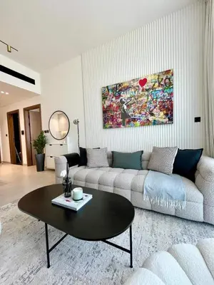 a living room with a couch and a table at Modern & Smart 1br W Stylish Interiors In Jvc in Dubai