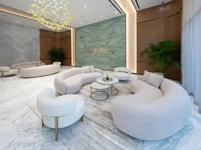 a lobby with white chairs and ottomans at Modern & Smart 1br W Stylish Interiors In Jvc in Dubai