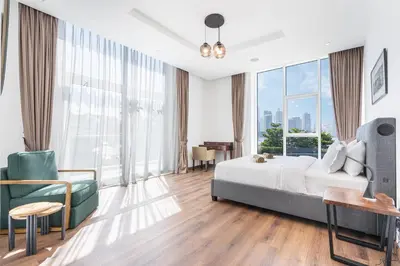 a bedroom with a bed and a desk and a couch at Palm Home next to Nakheel Mall with Private Beach in Dubai