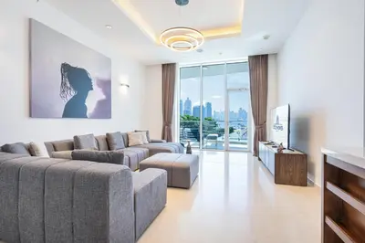 a living room with two couches and a tv at Palm Home next to Nakheel Mall with Private Beach in Dubai