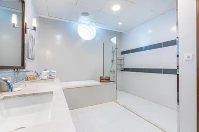 a bathroom with a tub and a sink and a shower at Palm Home next to Nakheel Mall with Private Beach in Dubai