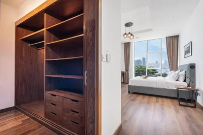 a bedroom with a large wooden closet with a bed at Palm Home next to Nakheel Mall with Private Beach in Dubai