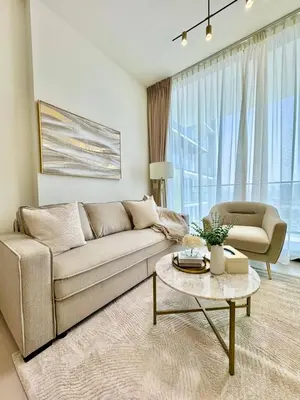 a living room with a couch and a table at Bright & Modern 1br In Jvc Pool Free Parking in Dubai