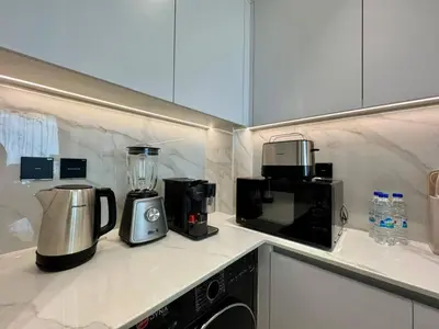 a kitchen with a microwave and appliances on a counter at Bright & Modern 1br In Jvc Pool Free Parking in Dubai
