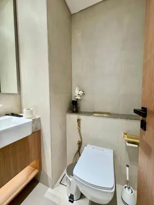 a bathroom with a white toilet and a sink at Bright & Modern 1br In Jvc Pool Free Parking in Dubai