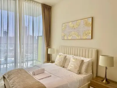 a bedroom with a bed and a large window at Bright & Modern 1br In Jvc Pool Free Parking in Dubai
