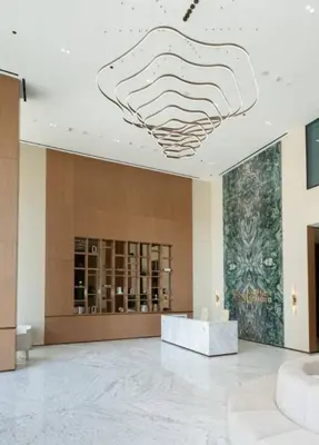 a lobby with a large chandelier hanging from the ceiling at Bright & Modern 1br In Jvc Pool Free Parking in Dubai
